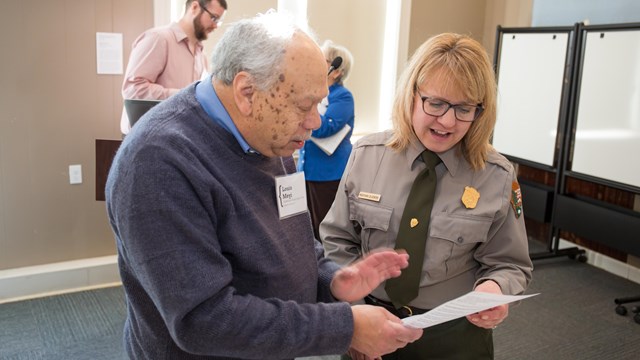 Two people look at a document together. 