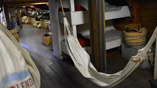 A hammock hangs in the tween deck aboard FRIENDSHIP OF SALEM.