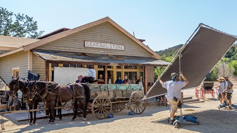 a crew filming on a western style set