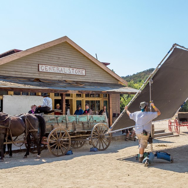 a crew filming on a western style set