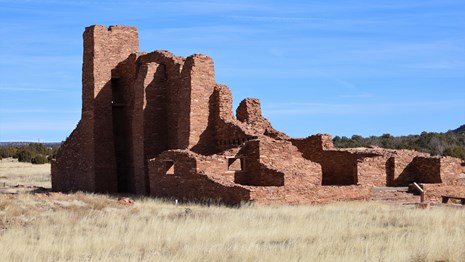 Red sandstone church ruins against a blue sky background