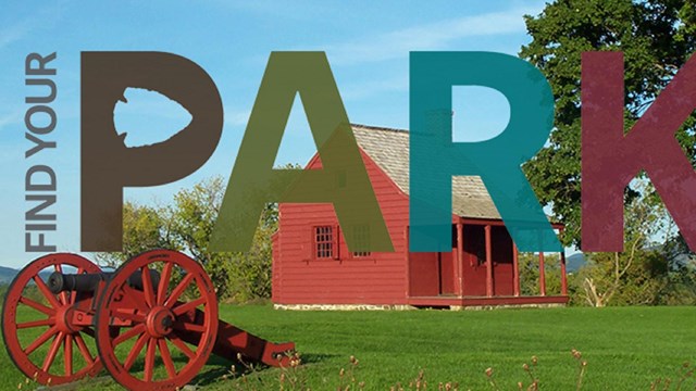 A red house in the distance, a red canon in the foreground, and a tree on a grassy lawn. 