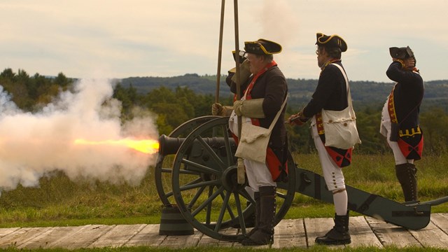 18th Century Soldiers fire a cannon.