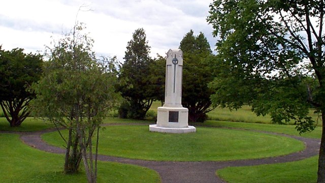 A tall white monument surrounded by a circular path