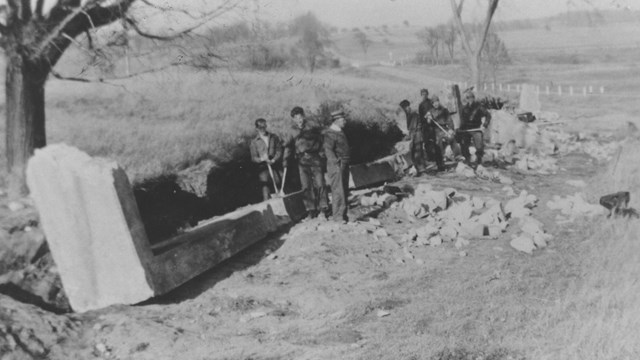 Historic black and white photograph of the CCC working with shovels in a field
