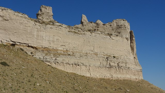 A large sandstone formation on which can be seen multiple layers of stratification.
