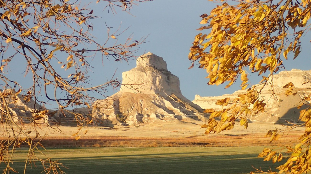 A distinctive sandstone bluff is framed by colorful, fall foliage. 