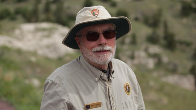 A bearded man wears a volunteer uniform.