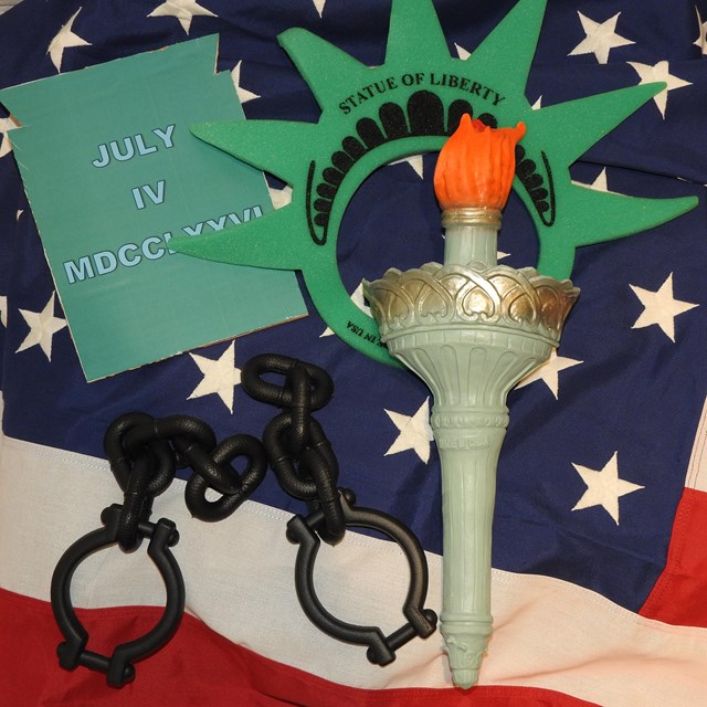 Statue of Liberty props rest on an American flag. 