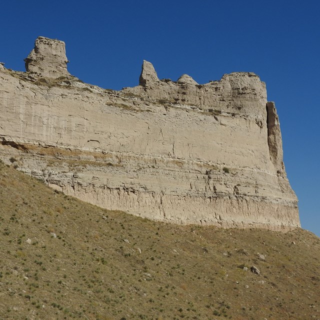 A large sandstone formation on which can be seen multiple layers of stratification.