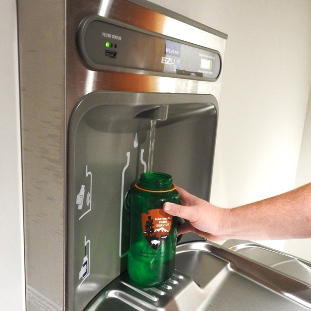 a water bottle filling station is used to refill a water bottle
