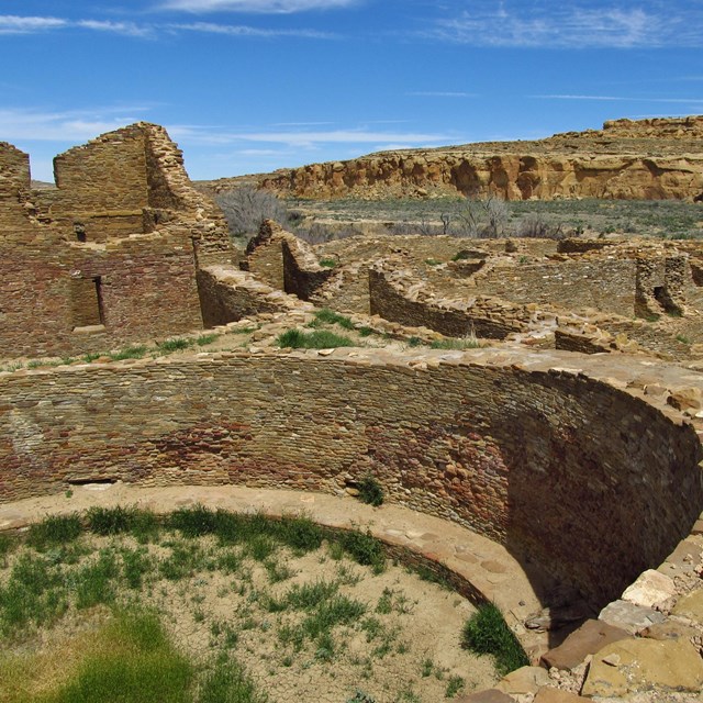 Ancestral Puebloan ruins with cliffs in the background