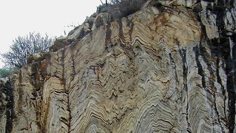A sheer cliff face with visible folded layers