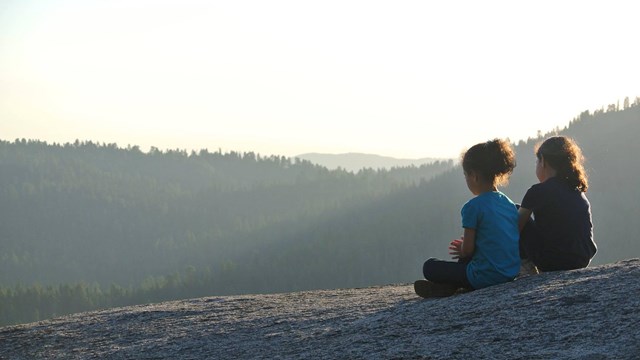 Two small children sit, enjoying the view. Photo by Tharwa Rabah.