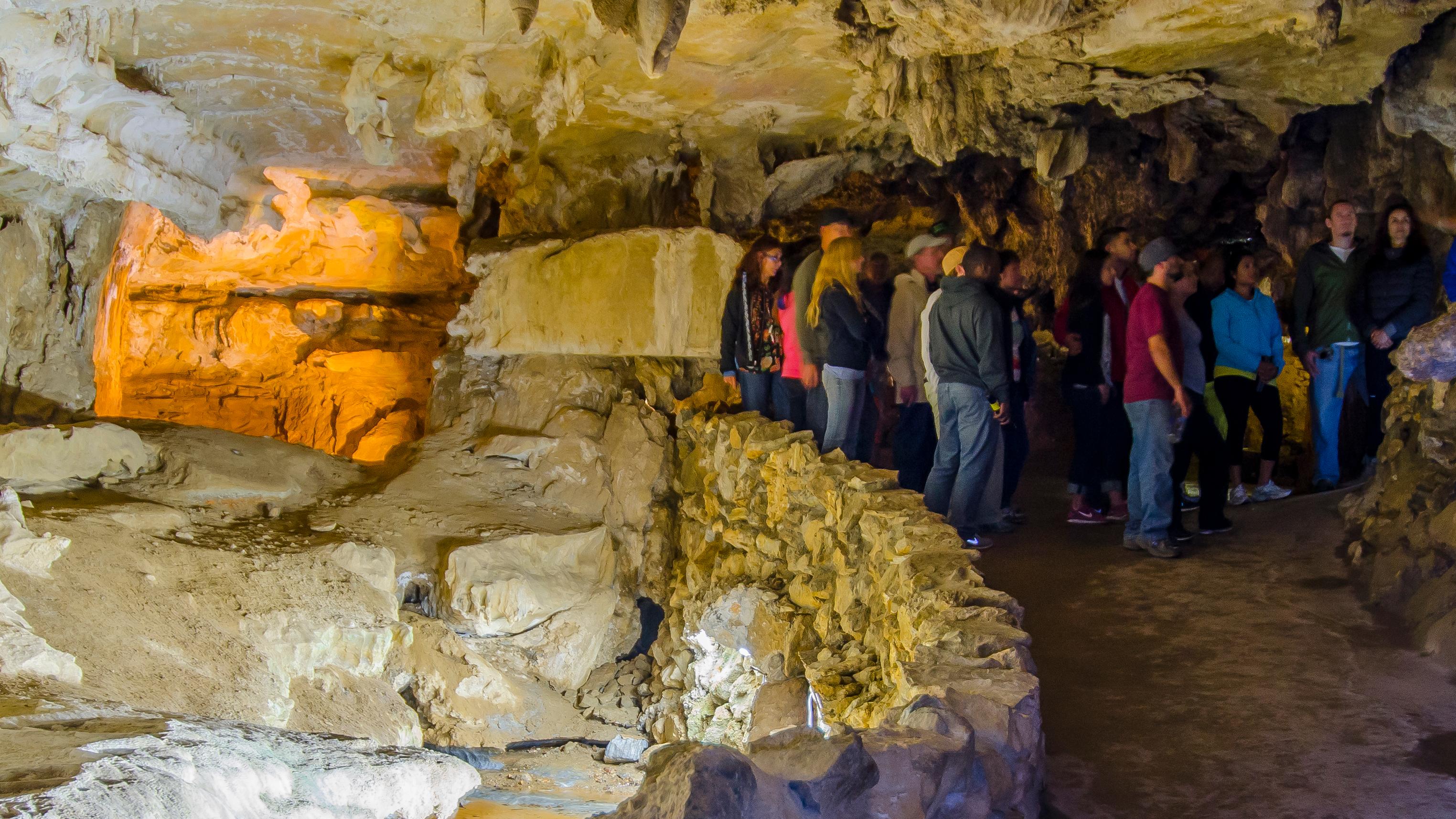 A group of people in a cave room near a stream. Photo by Alison Taggart-Barone.