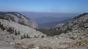 A distant hazy sky with particulate matter forms over Sierra mountains.