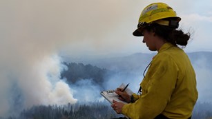 A firefighter records smoke observations