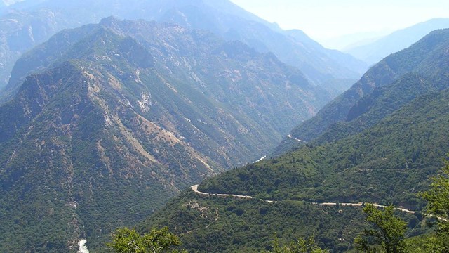 A road traverses through the mountainous Kings Canyon National Park.