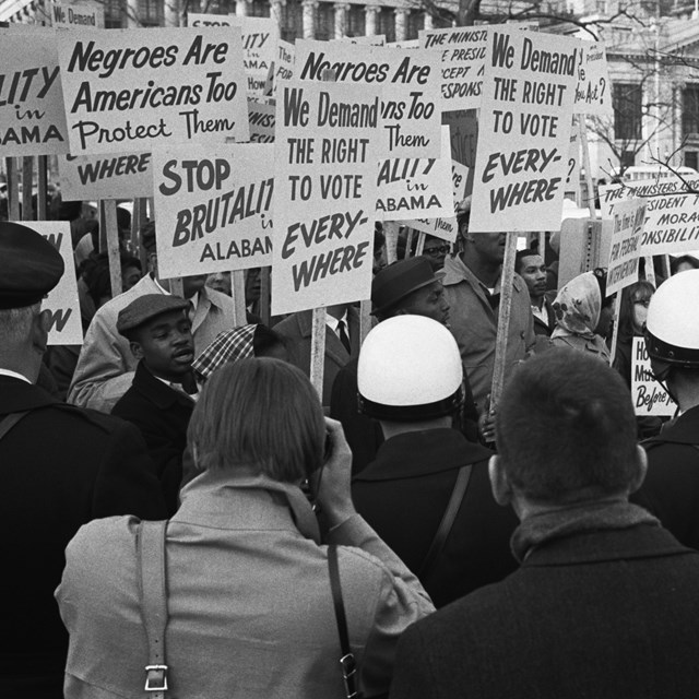 Black and white photo of people protesting voting restrictions