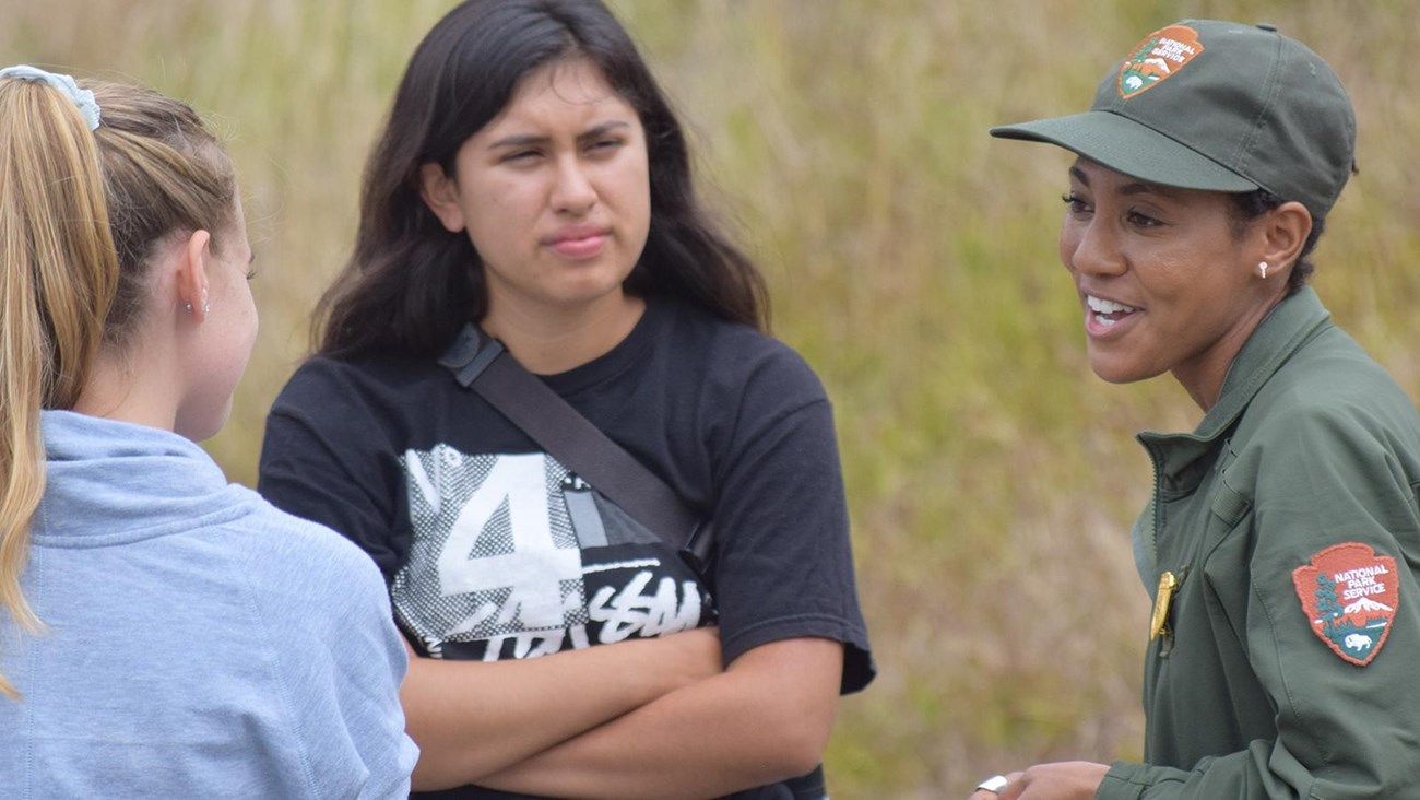 Ranger in uniform chats with park visitors