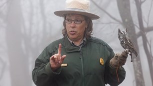 Ranger standing in fog with one finger raised.