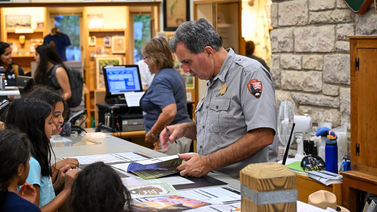 A park ranger assists a visitor in the visitor center