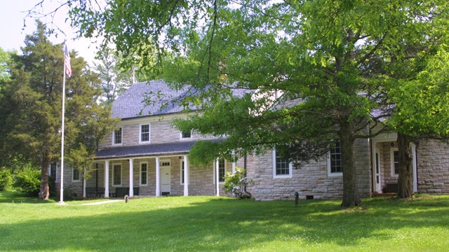 A wide shot of the stone headquarters building, flagpole and lawn of Shenandoah National Park.  