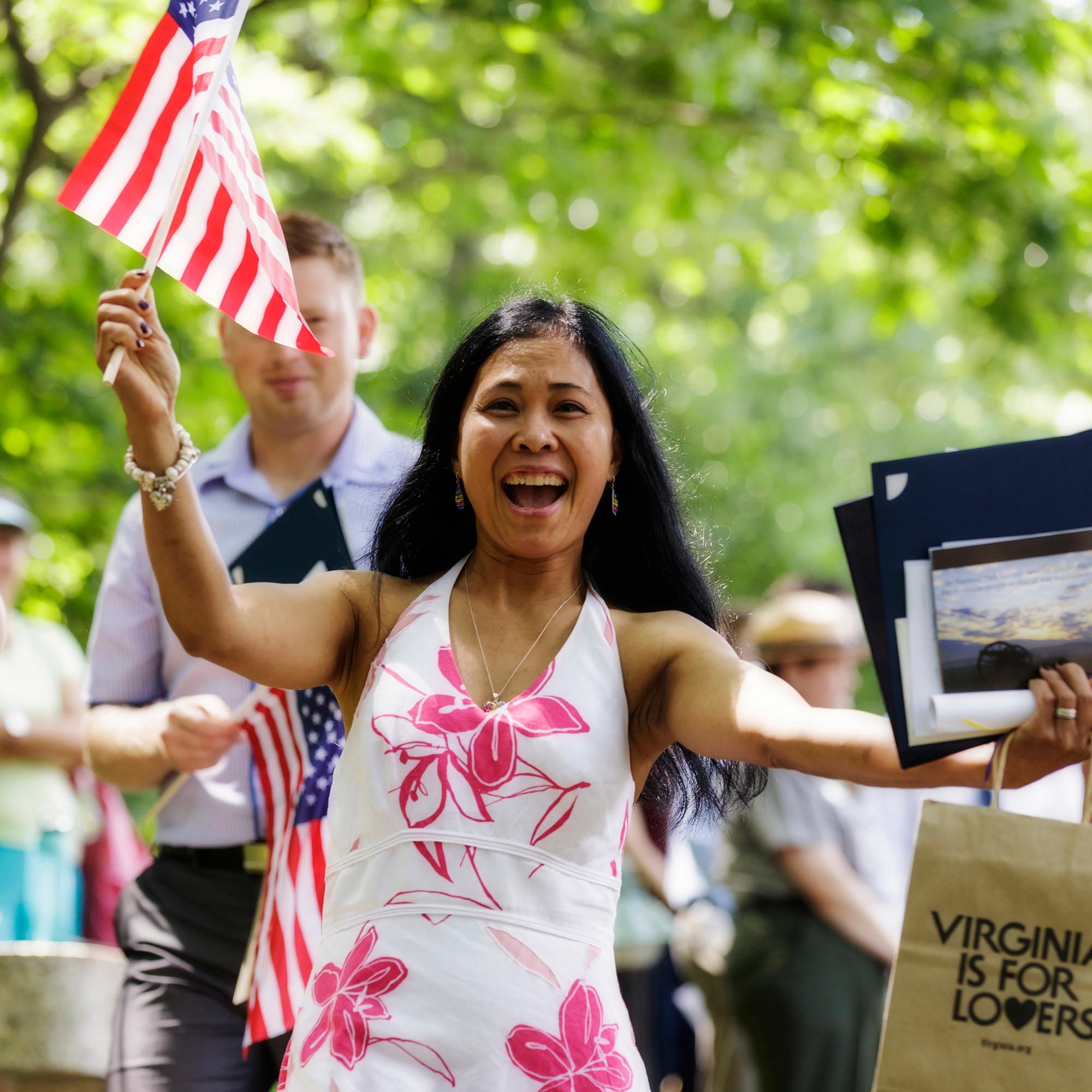 Woman holding flag at a naturalization ceremony.