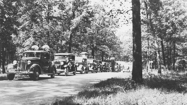 Black and white image of old automobiles touring Shiloh. 