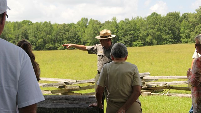 A ranger in green and gray pointing