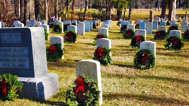Green wreaths with red ribbons adorn stoned in the national cemetery. 