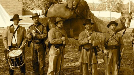Image of living historians standing in front of a camel
