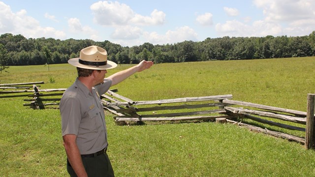 Ranger pointing across a field