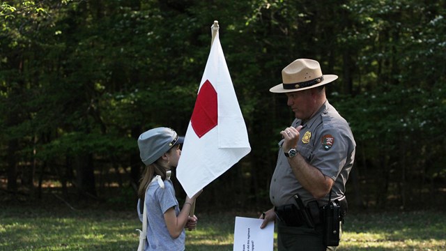 A young girl gets instructions from a park ranger. 