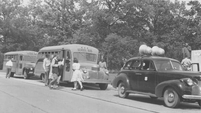 Historic image of a car leading buses at Shiloh circa 1930