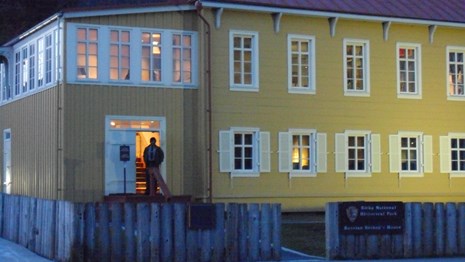 The Russian Bishop's House in the evening. A man is standing in the doorway.