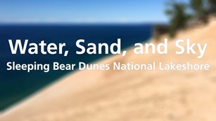 text Water Sand and Sky Sleeping Bear Dunes National Lakeshore on a blurred  image of sand 