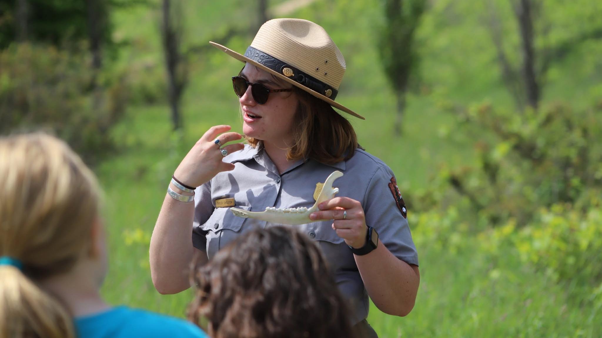 A woman in uniform holds a prop