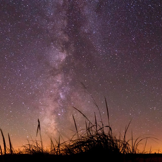 The milky way galaxy over a sandy dune. 
