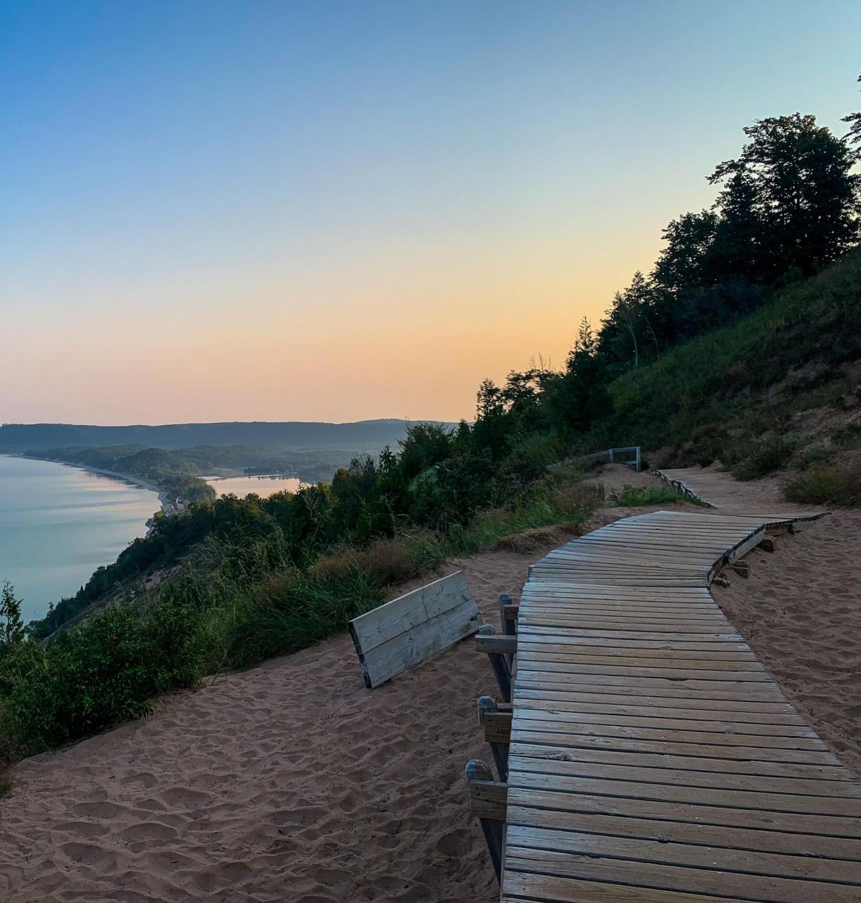 A wooden boardwalk on a high bluff with a view of a large lake beyond.