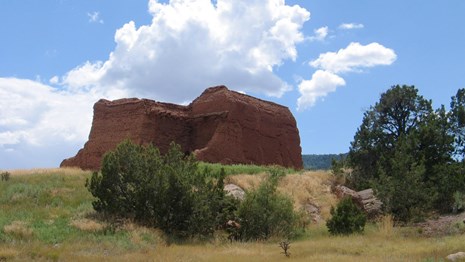 A grassy area with the ruins of a mission at Pecos National Historical Park.
