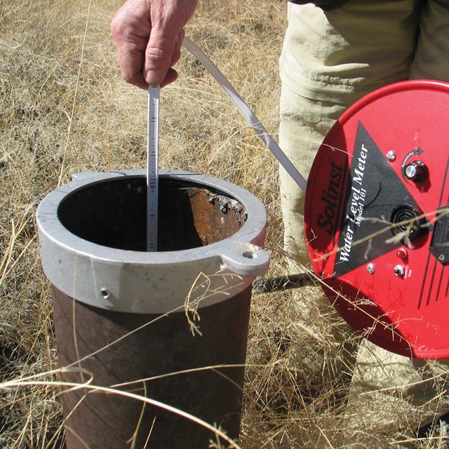 Lowering a measuring device into a groundwater well