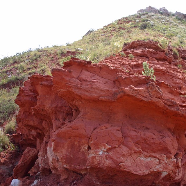 Rocky outcrop exposing red rock and soil in Lake Meredith NRA dating back to the Permian