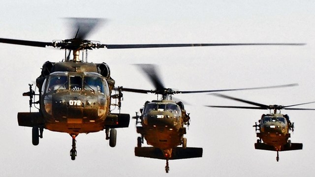 Frontal view of three military helicopters in flight
