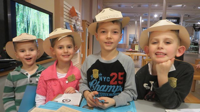 Four young kids with Junior Ranger Paper Hats 
