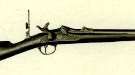A black and white photo of a trapdoor rifle. 