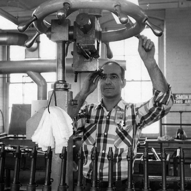 a man looks through a barrel straightening machine