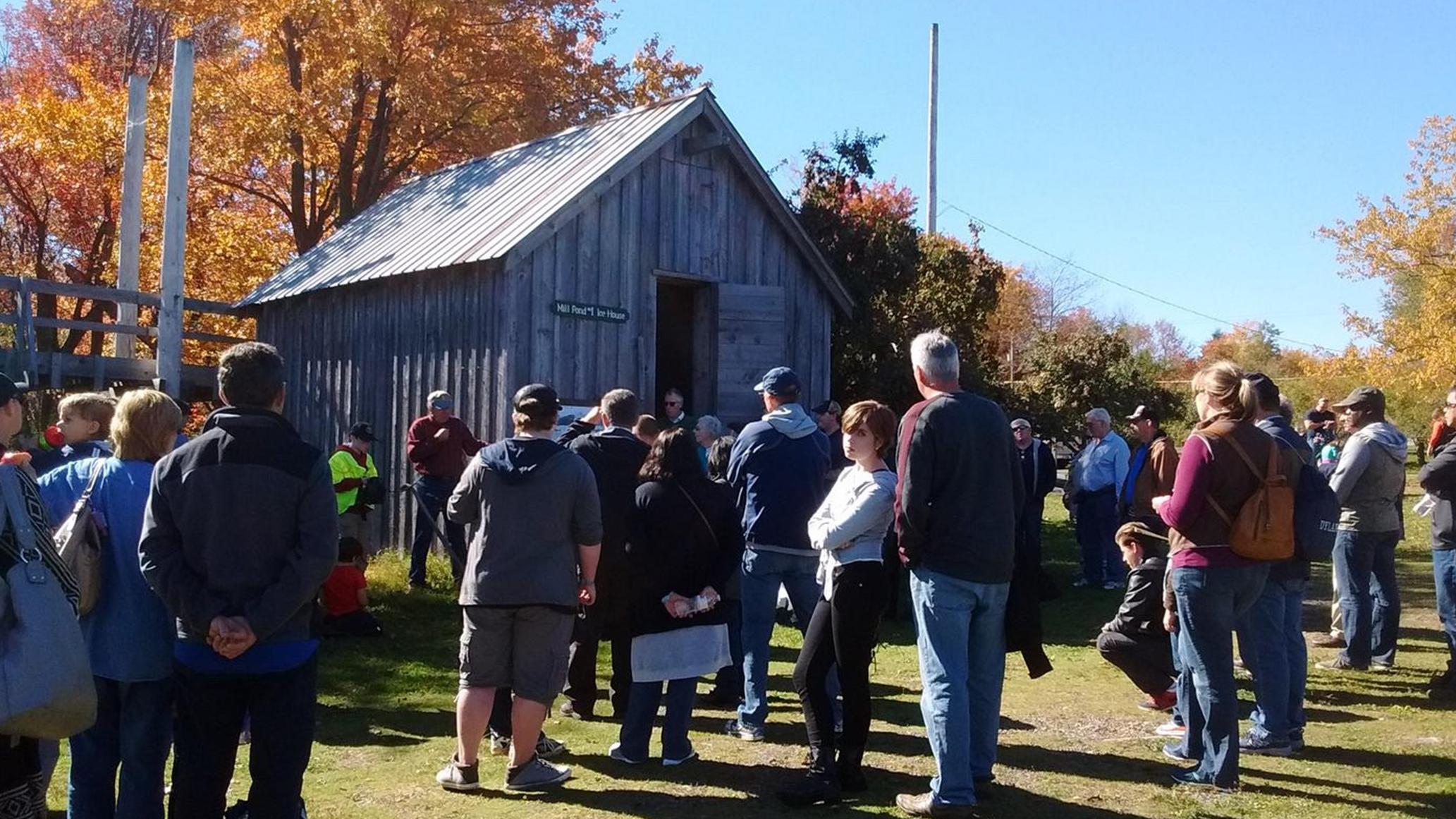 Group of visitors gathered around the icehouse exhibit at Tobyhamma