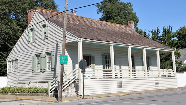 White house with a cedar shingle roof. 