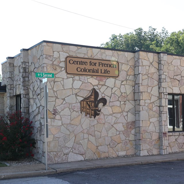 Cream colored stone building with golden sign on the side